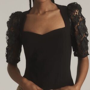 NYT Dolan faux leather cutwork puff-sleeve black blouse from Anthropologie.
